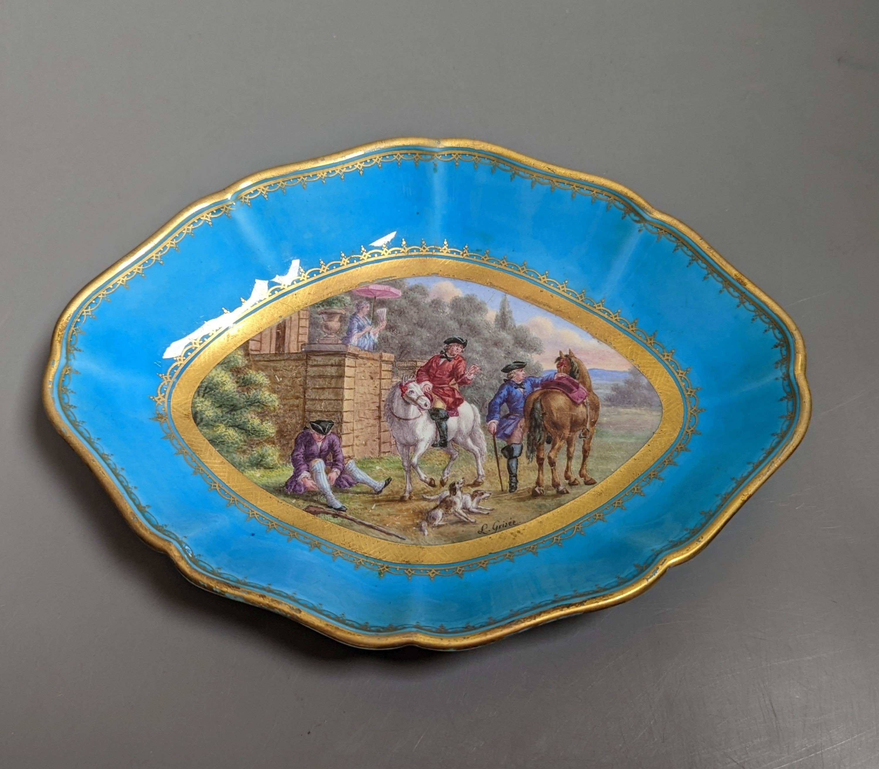 A 19th century Sevres oval shaped dish painted with a hunt scene, with three gentlemen, two dogs two horse and a lady watching surrounded by a turquoise and gilt ground, signed L Grise'e, 19cms wide